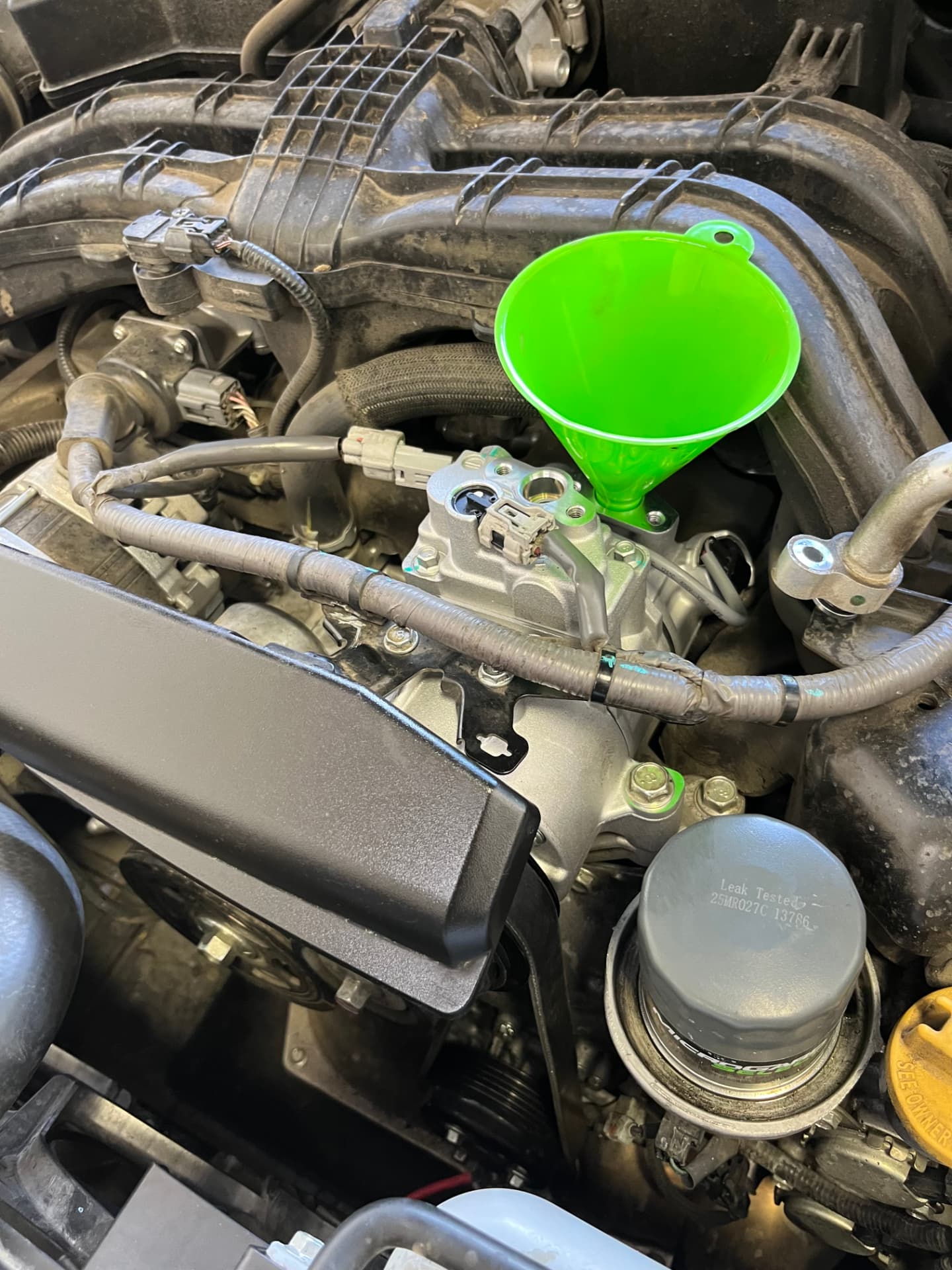 New air conditioning compressor being installed in a Subaru at Johnny's Auto Repair near Spring Valley Lake in Victorville CA