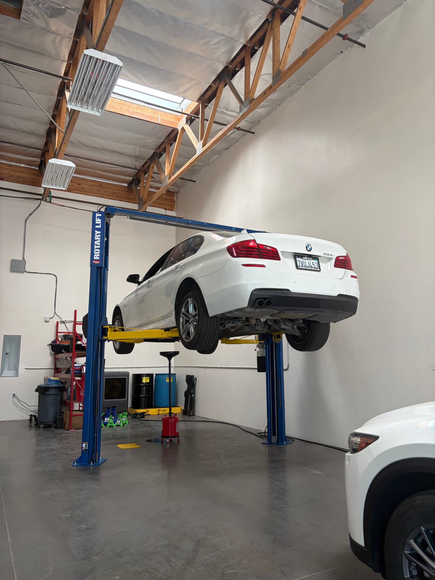 BMW raised on a vehicle lift inside Johnny's Auto Repair on Ridgecrest Road
